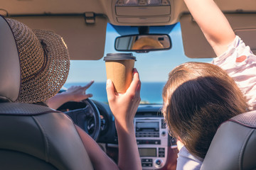 .Two girls traveling by car on the Italy. One of them is looking map