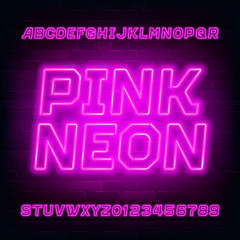 Pink neon alphabet font. Bright light bulb letters and numbers. Stock vector typeface for your typography design. Brick wall background.