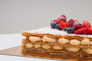 Simple layer cake with berries. Sweet crispy dessert on table. Recipe of cake concept
