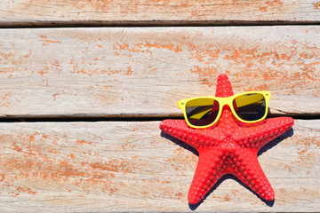 starfish with sunglasses on wooden background