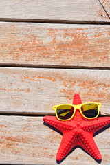 starfich with sunglasses on wooden background