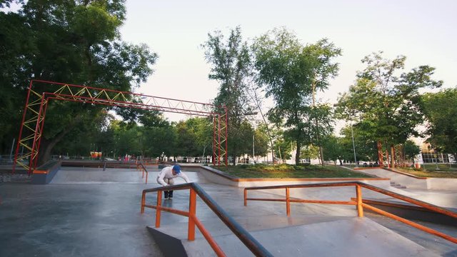 Aggressive Inline roller skater doing tricks in concrete skatepark outdoors, slow motion, tracking shot