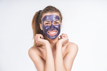 close-up young cheerful girl in a cosmetic mask on her face. Emotional portrait with hands near face, natural look, no makeup.