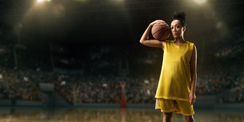 Obraz na płótnie Canvas Female basketball player with ball on big professional arena 