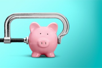 Pink piggy bank and clamp on background