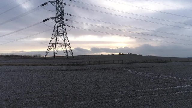 Flying along a field toward a pylon then rising up, Drone, Batley, Yorkshire