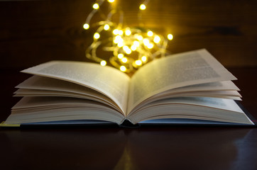 open book light in the dark wooden background