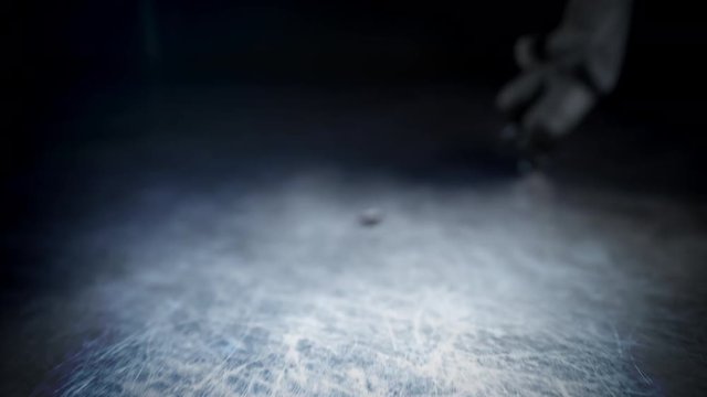 Hockey player in white uniform hits the puck in slow motion