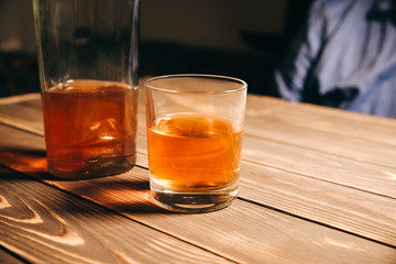 Alcoholic addict. Man near the table with alcohol and a glass. Dangerous habit. Unhealthy life concept. Social problem.