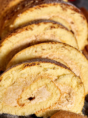 Slice rolled biscuit cake with cream for breakfast dessert close up.