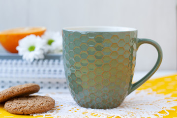 A study break: a cup of tea, cookies and a half of an orange.