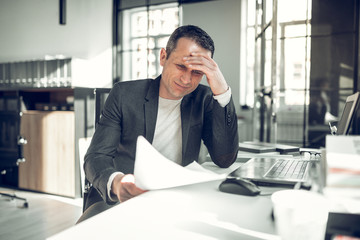 Businessman having too many complications working on report