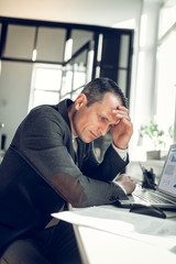 Naklejka premium Businessman touching his head while feeling busy of work