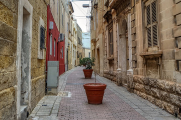 The narrow street in old town of Mosta decorated with flowers
