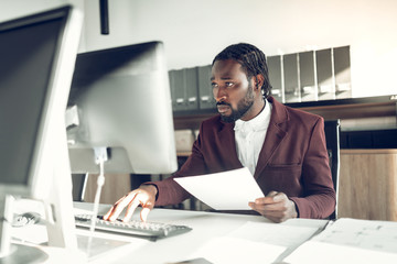 Naklejka premium Dark-skinned businessman working on computer in the office