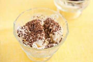 Ice cream dessert with chocolate and currant jam on yellow table-napkin. Selective focus