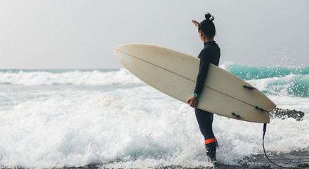 Woman surfer with surfboard going to surf