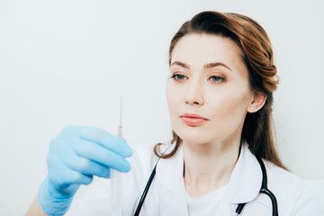 doctor in white coat and latex glove holding syringe isolated on white