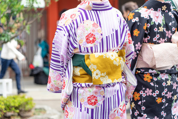 Young girl wearing Japanese kimono standing in front of Sensoji Temple in Tokyo, Japan. Kimono is a Japanese traditional garment. The word 