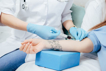 cropped view of donor and doctor with syringe obtaining blood sample