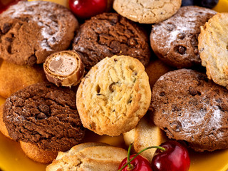 Oatmeal cookies and sand chocolate cake with raisins on wooden table in farm style close up.