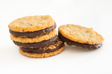 Oatmeal cookies and chocolate on white background