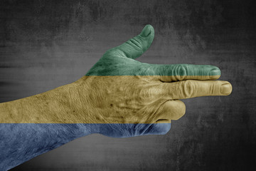 Gabon painted flag on male hand like a gun