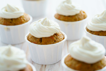 Fototapeta na wymiar Carrot cupcakes with vanilla frosting. White wooden table, high resolution