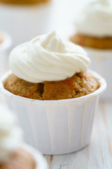 Carrot cupcakes with vanilla frosting. White wooden table, high resolution