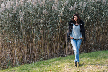 Beautiful brunette standing on a background of reeds.