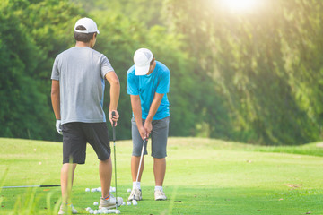 Golfers playing golf on the lawn green in the morning.