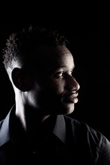 portrait of a african man on black background, profile