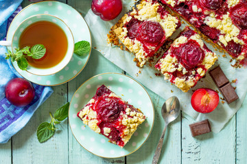 Sweet pie, tart with chocolate and fresh plum. Delicious cake with plum on kitchen table. Top view flat lay. Free space for your text.