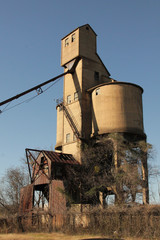 Tall grain mill left abandoned along a train track