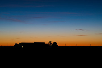 Fototapeta na wymiar Twilight colors above a dutch farm in the period of the short summer nights, The Netherlands