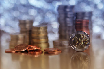 copper coins of the European Community worth 5 cents amid stacks of coins, rear items blurred