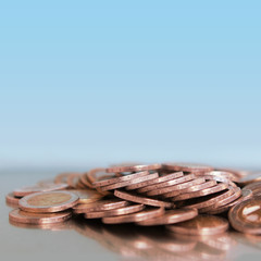 copper coins, loose currency of the EU countries, on a blue background, copy space