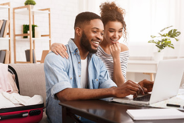 African-American Couple Searching Tour Online On Laptop
