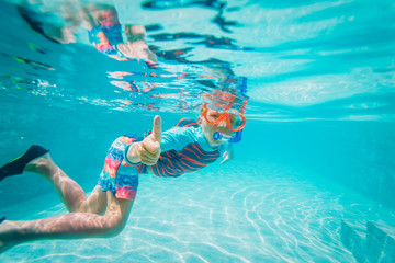 happy boy swim underwater with thumb up