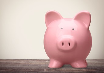 Blue piggy bank in glasses on background