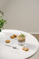 Ready to eat healthy an nutritious breakfast - granola with almonds, chia seeds, banana and kiwi fruits and berries and a jar with milk nearby