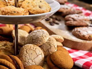 Oatmeal cookies on red kitchen gingham checkered cotton fabric on table in farm-style. Macaron close up. Checkered tablecloth. Tier cake stencil.