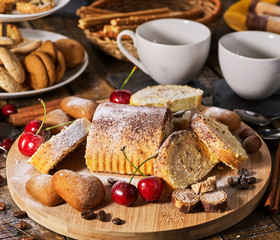 Cookies heart shape, sand rolled biscuit and cinnamon stick on wood table served dessert spoon at kitchen in rustic style. Morning sun flare. Cooking various dishes.