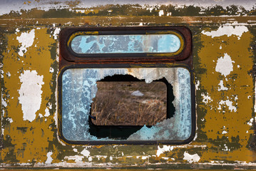 Front view of the broken window glass of the old abandoned rusty bus