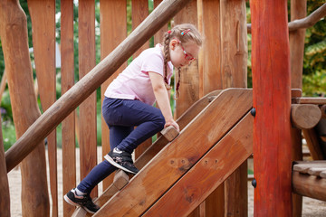 young girl in glasses goes in for sports on the playground. rest and childhood outdoors