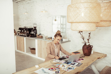 Smiling lady working on her clothes designs.