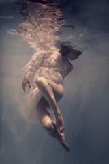 Portrait of a girl in a dress under water