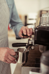 Barista making coffee near the coffee machine.