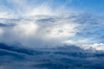 through the dark and white clouds you can see the blue sky.