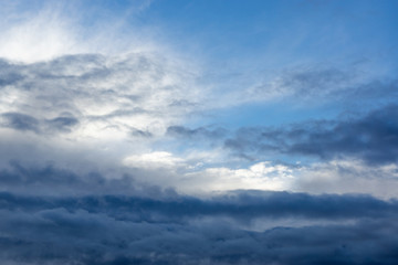 Fototapeta na wymiar through the dark and white clouds you can see the blue sky.